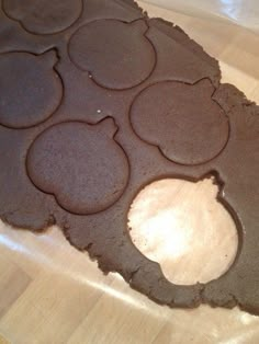 a chocolate cookie with holes in the middle on a wooden counter top, ready to be cut into pieces