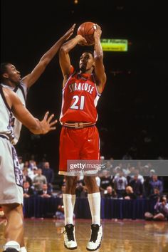 the basketball player is trying to dunk the ball in front of the other player