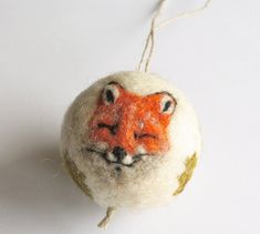 an ornament made to look like a ball with a fox face on it