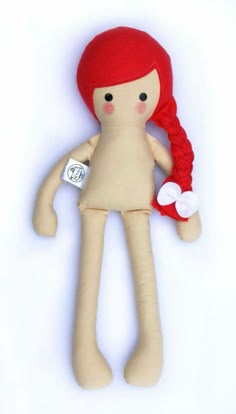 a small doll with red hair holding a white tag on it's back end