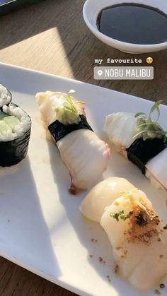 sushi is served on a white plate with chopsticks next to it and a cup of coffee in the background