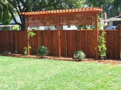 a wooden fence in the middle of a yard