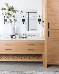 a bathroom with two sinks and wooden cabinets