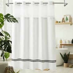 a bathroom with a white shower curtain and black trimmings on the shower curtain