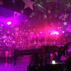 the stage is lit up with purple lights and stars hanging from it's ceiling