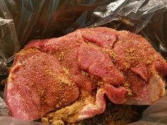 a piece of meat sitting on top of tin foil covered in seasoning and spices