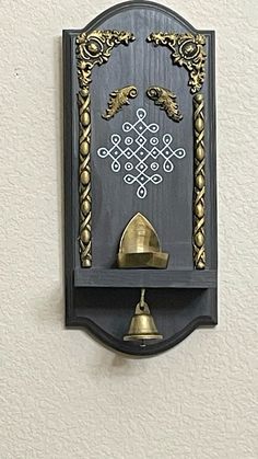 a clock mounted to the side of a wall with two bells on it's sides