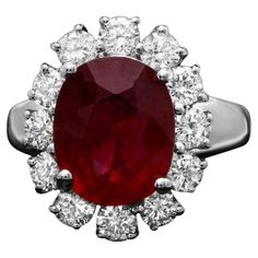 an oval shaped ruby and diamond ring with white diamonds around the band, set in 18k white gold