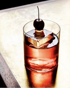 a cherry sitting on top of a glass filled with liquid