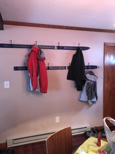 there are two coats hanging on the coat rack in this room, one is red