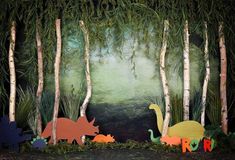 paper cutout dinosaurs in the woods at night