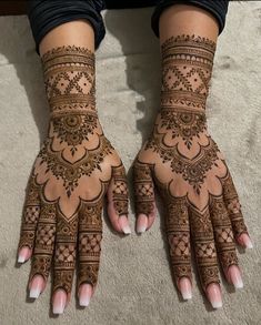 two hands with henna designs on them