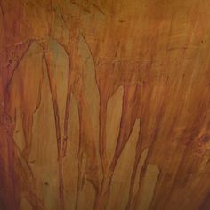 a close up view of a wooden table with brown and yellow paint on it's surface