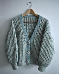 a cardigan sweater hanging on a hanger