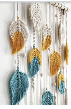 a wall hanging made out of macrame beads and tassels with feathers