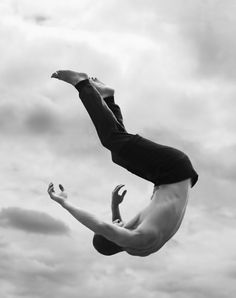 a man flying through the air while riding a skateboard in front of a cloudy sky