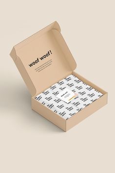 an open cardboard box with white and black wrapping paper in it that says woow