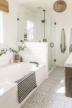 a bathroom with a bathtub, sink and shower in it's own area