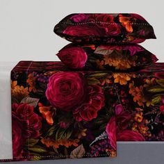 three pillows and two pillow cases with colorful flowers on them, all stacked up together