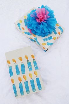 two birthday cards with candles on them and a tissue paper flower in the middle one