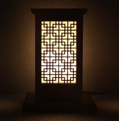 a lamp that is lit up in the dark with an intricate design on it's side