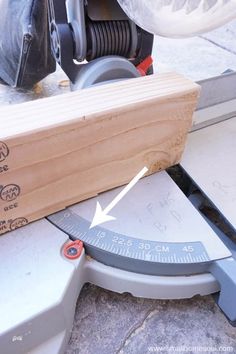 a close up of a wooden object with a ruler on the ground next to it