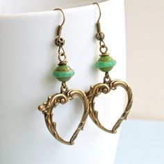 "Heart Earrings - Ornate Antiqued Brass Hearts dangle from Turquoise Czech Glass Bicones. These earrings have a Victorian look to them. Hearts are 27mm x 23mm and have hollow backs. The earrings measure just under 2.25\" from top of earwires to bottom of hearts. Antiqued Brass Earwires" Vintage Dangle Heart Beads Jewelry, Vintage Jewelry With Heart Beads And Dangle Shape, Green Heart Beads Earrings For Gift, Vintage Dangle Jewelry With Heart Beads, Green Earrings With Heart Beads For Gifts, Vintage Heart Charm Drop Earrings, Green Heart-shaped Bohemian Earrings, Green Heart-shaped Earrings For Valentine's Day, Elegant Turquoise Heart Earrings