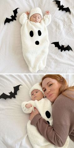 a woman holding a baby in a crocheted costume with bats flying around her