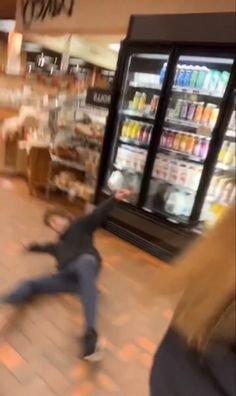 a blurry image of a person running in front of a vending machine at a grocery store