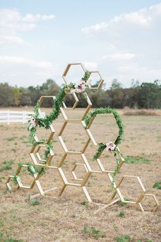 a sculpture made out of hexagonal blocks with flowers and greenery