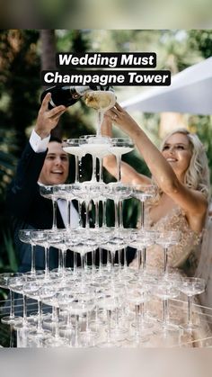 a bride and groom are toasting with champagne in front of a large stack of wine glasses