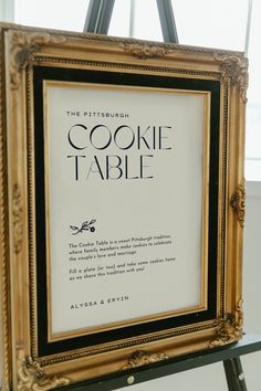 a sign that is on top of a easel in front of a window with the words cookie table written below it