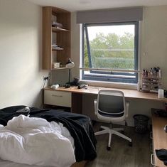 a bedroom with a bed, desk and window