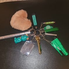 several different items are laying out on the table with one keychain and two pens