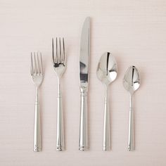 four forks, two spoons and one knife on a white surface