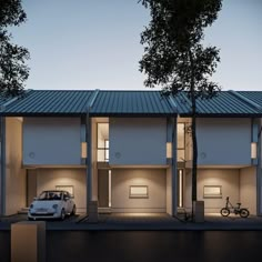 a white car parked in front of a building with lights on it's windows