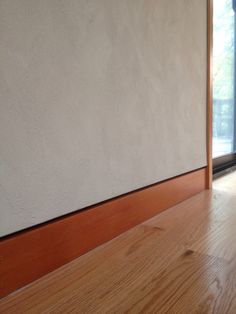 an empty room with wood floors and white walls