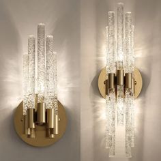 two wall lights that are next to each other on a white wall with gold trimmings