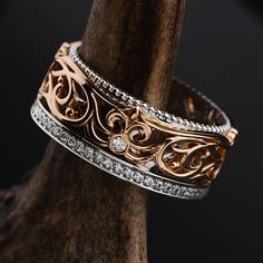 a close up of a ring on a tree branch with diamond accents and filigrees