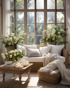 a living room filled with lots of furniture and flowers in vases on the windowsill