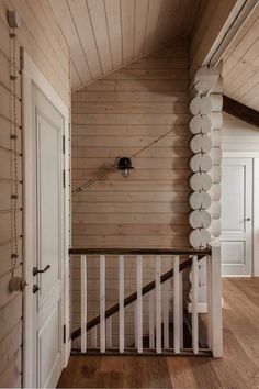 an empty room with wooden walls and white railings