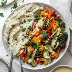 a white bowl filled with vegetables covered in sauce next to other dishes on a table