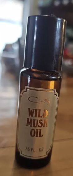 a bottle of wild musk oil sitting on top of a wooden table