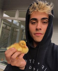 a young man holding a small yellow duck