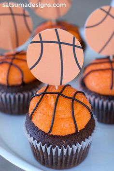 cupcakes with basketball decorations on them sitting on a plate