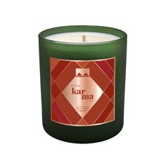 a green candle with an orange and red design on the top, in front of a white background