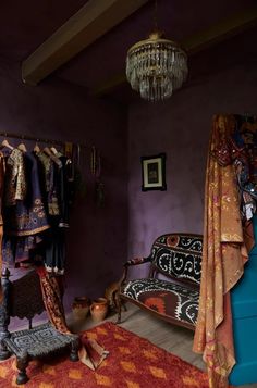 a bedroom with purple walls and an ornate bed in the corner, chandelier hanging from the ceiling