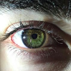 an extreme close up shot of a person's green eye