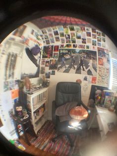 the reflection of a person sitting in a chair with pictures on the wall behind them