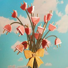 a vase filled with marshmallows and lollipops on sticks in the sky